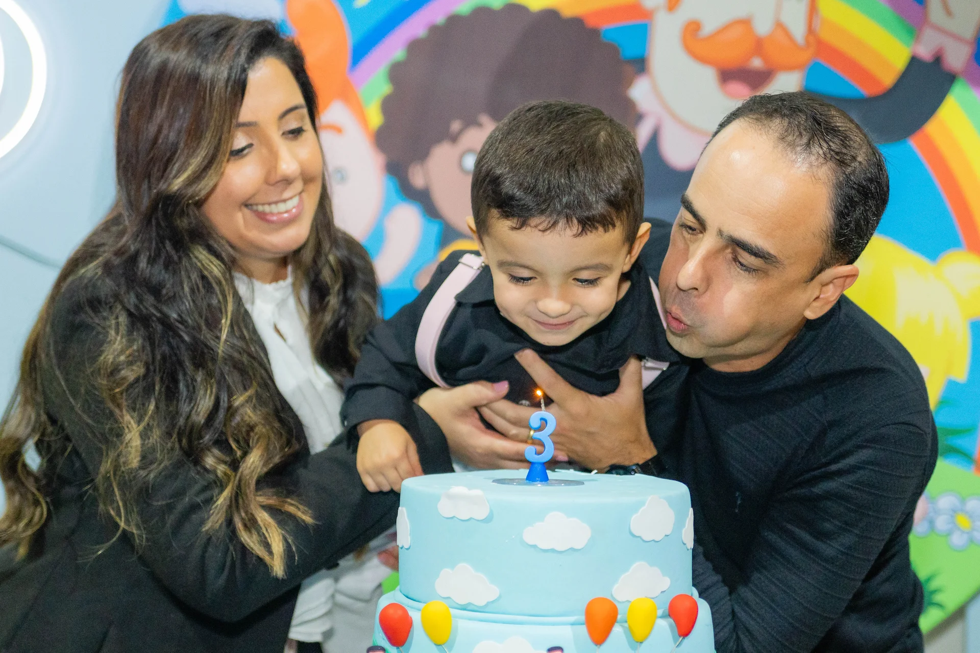 Criança assoprando a vela do bolo de aniversário de 3 anos